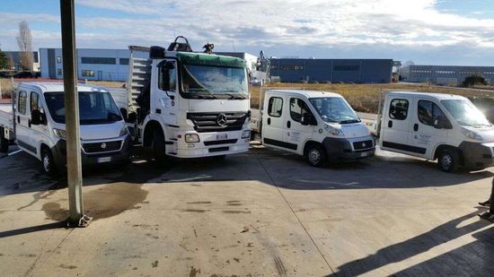 un gruppo di camion bianchi parcheggiati uno accanto all'altro