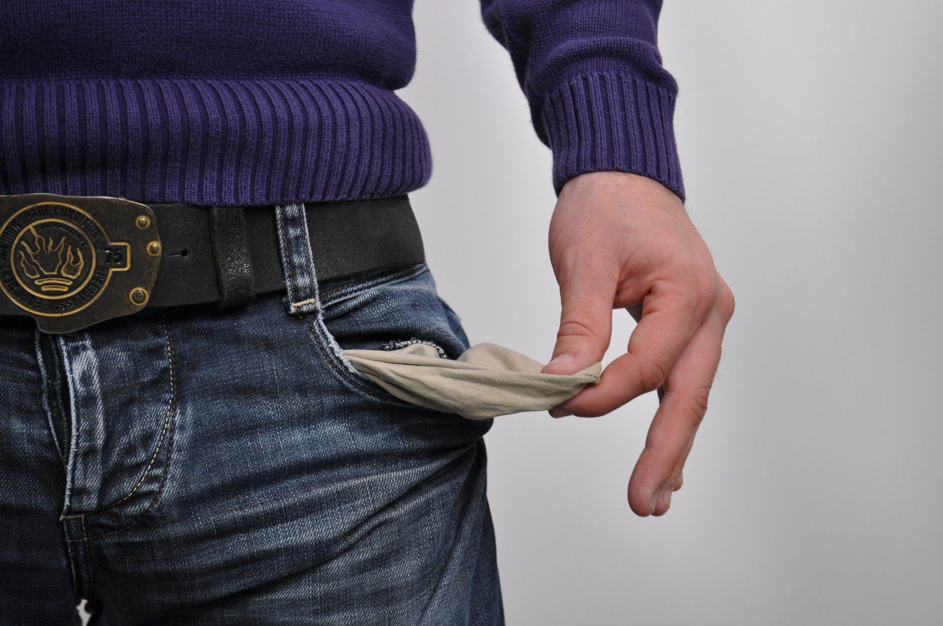 A man in a purple sweater with empty pocket.