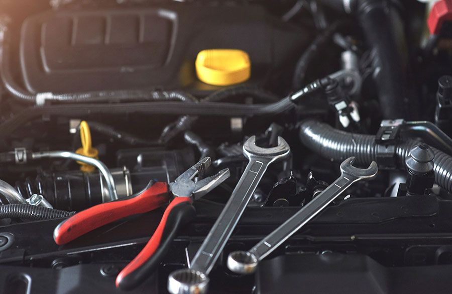 Tools and red-handled pliers on a car engine bay