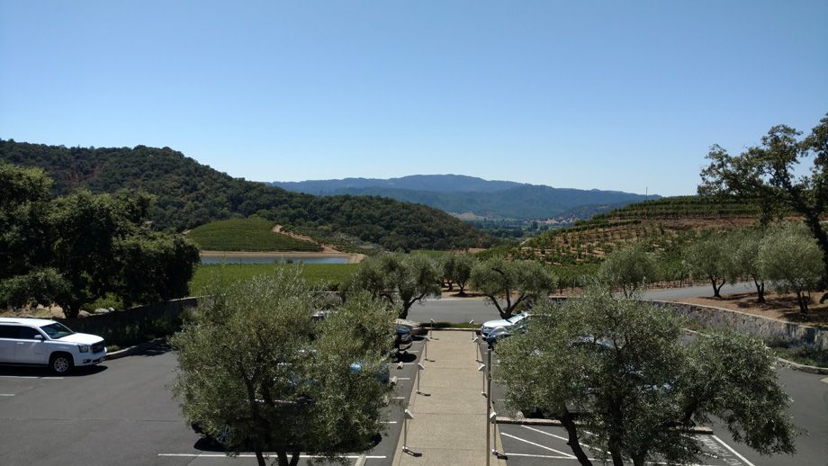 Parking lot overlooking green hills and valley under a clear blue sky