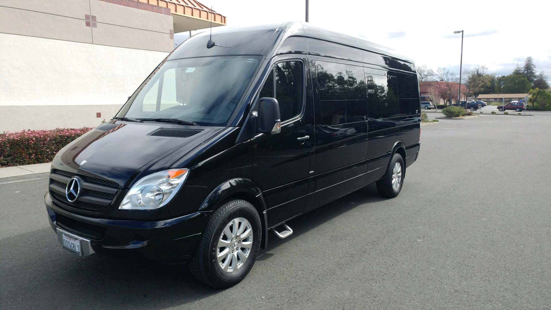 Black luxury limousine parked with its rear door open on a street