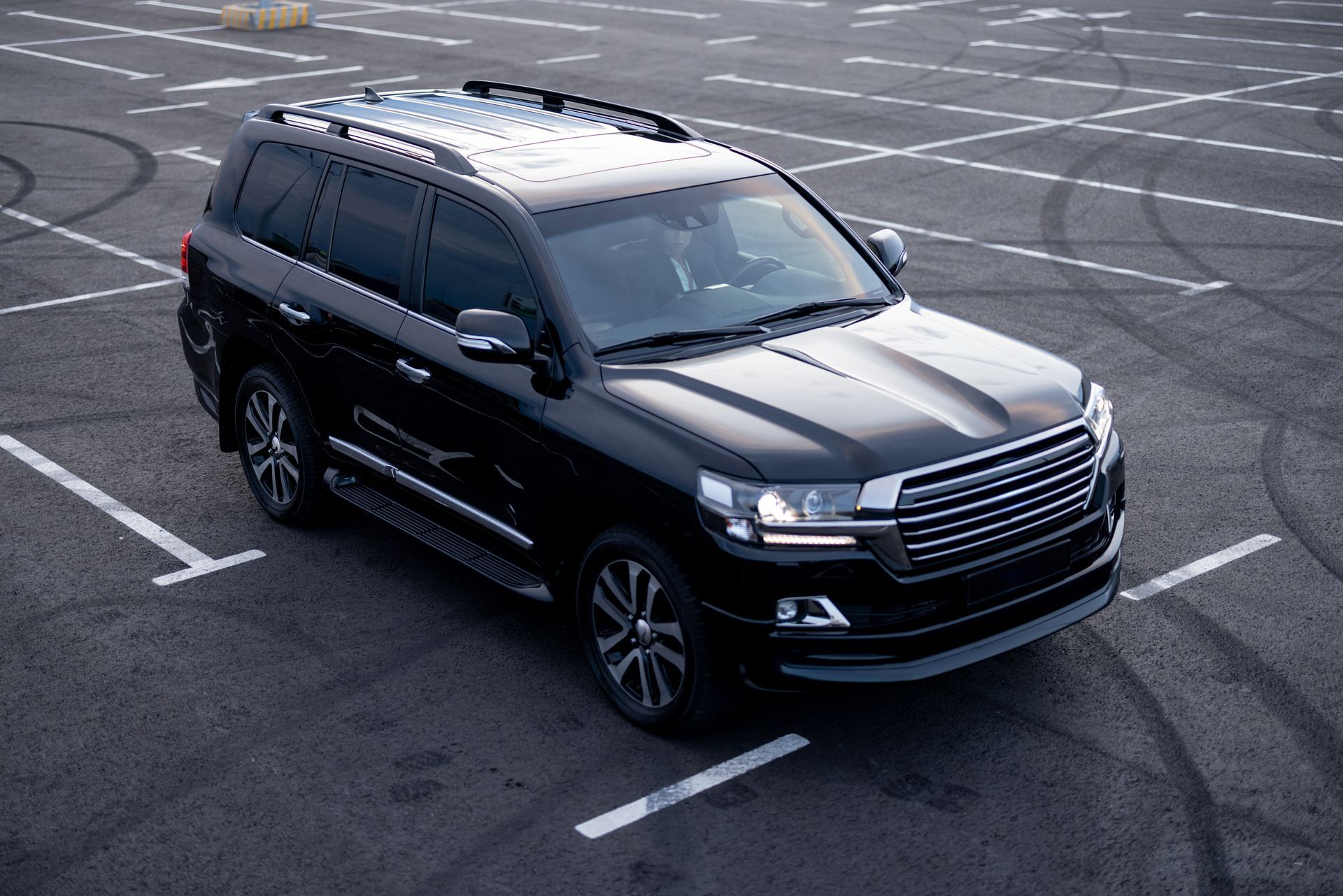 Black SUV parked in a marked lot, viewed from above at an angle.