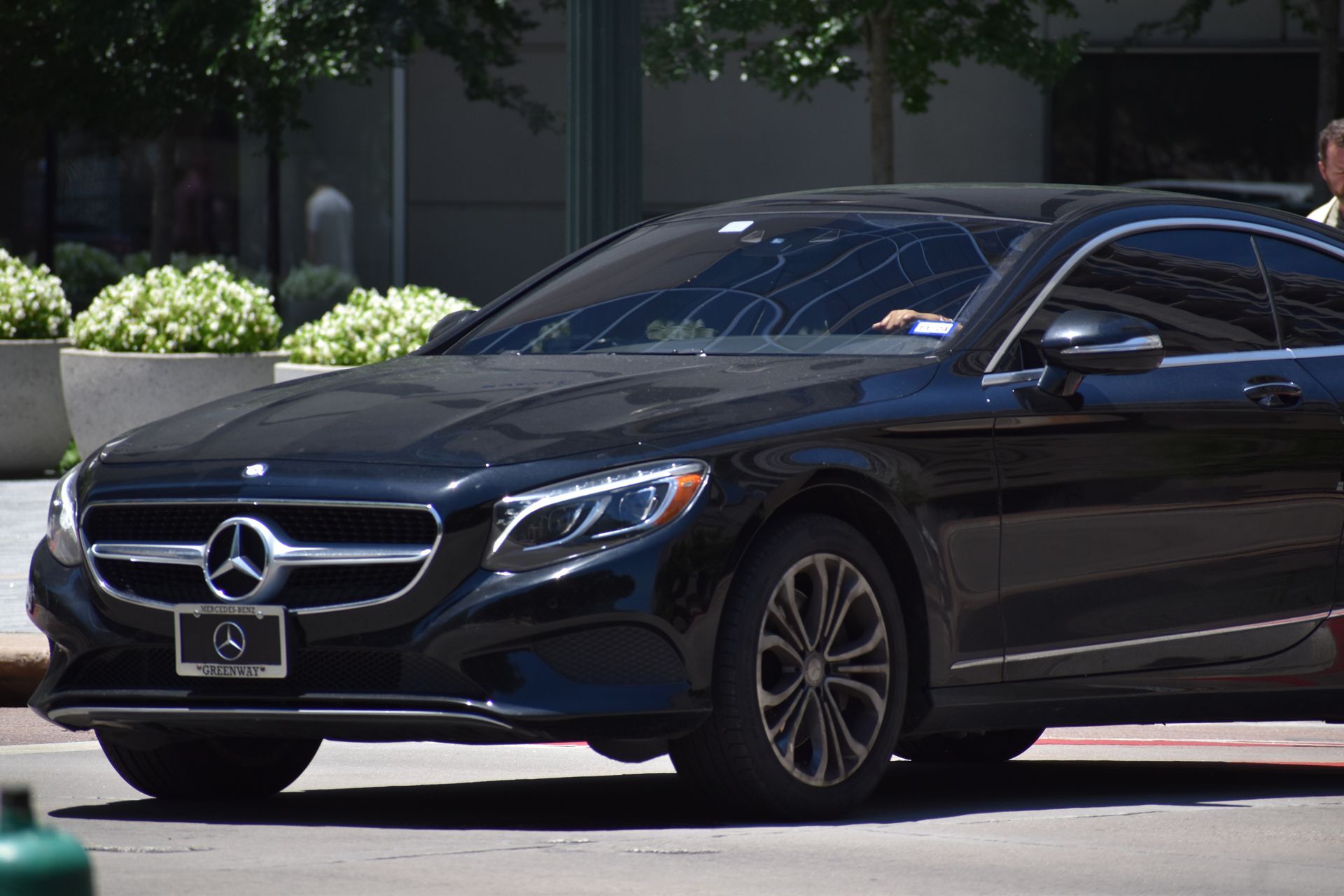 Black Mercedes-Benz sedan parked outdoors in front of a building