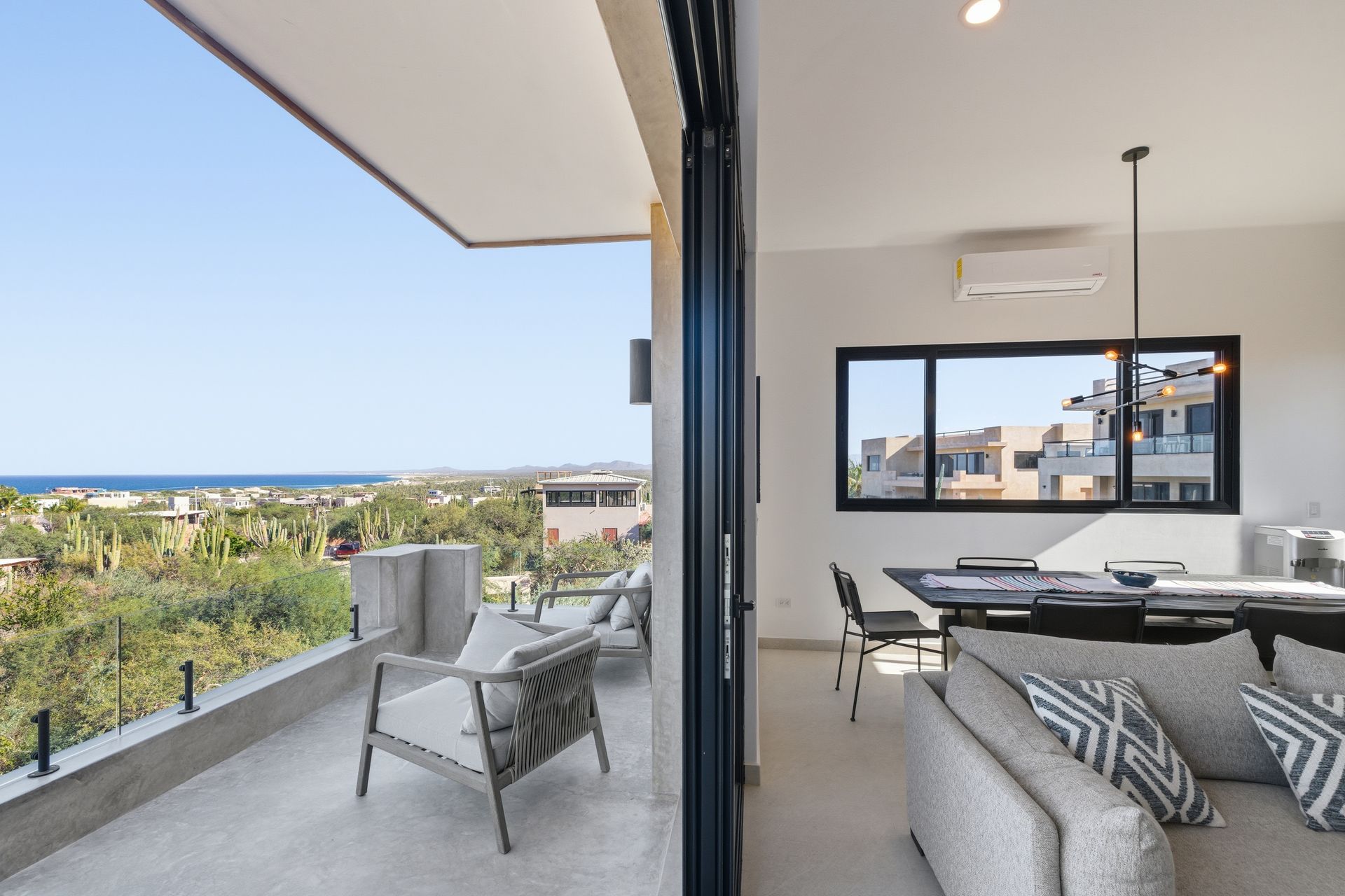 Balcony with ocean view and modern interior living room with furniture.