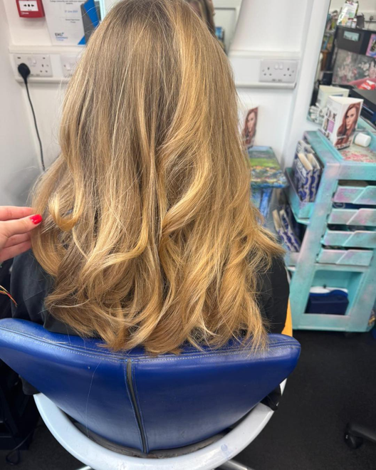 Back-view-of-shoulder-length-highlighted-blonde-hair-with-soft-waves-seen-in-a-hair -salon