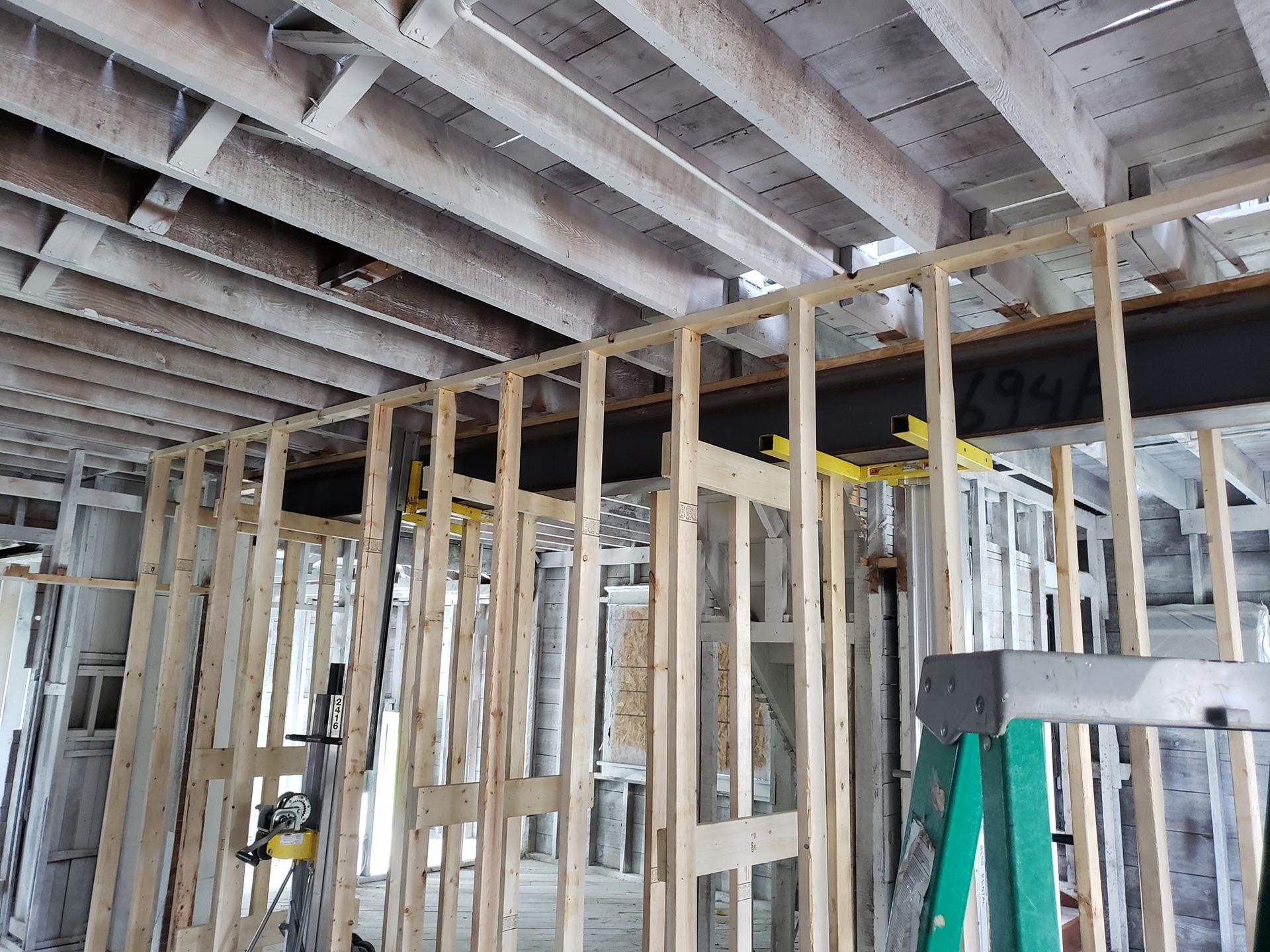 Interior of a house under construction with exposed wood framing and ceiling joists