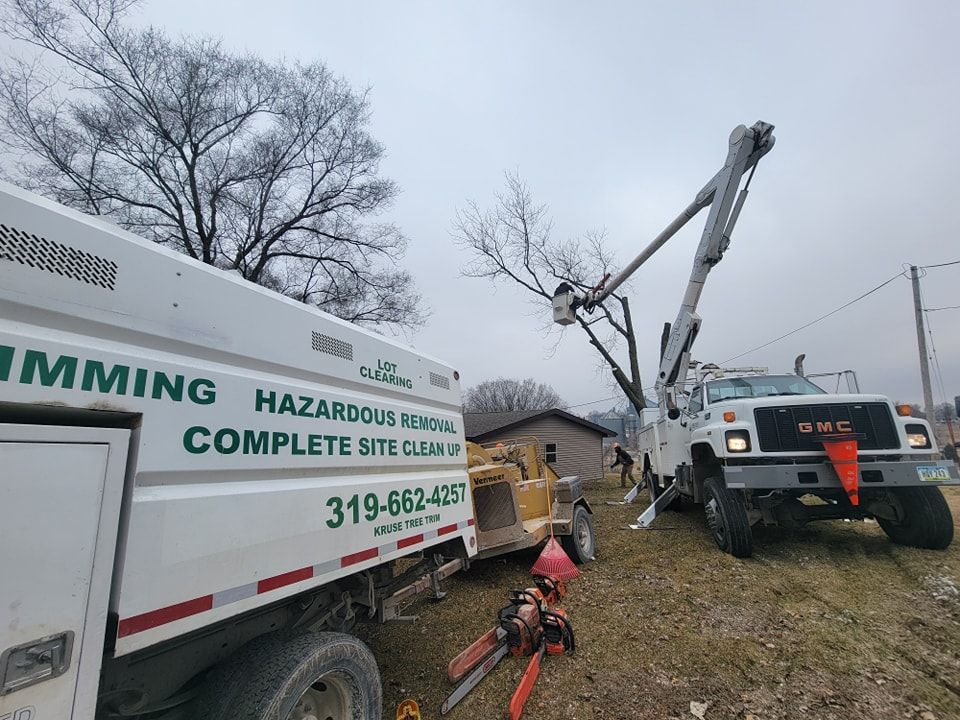 Utility crew repairing a downed pole beside a white service truck on a muddy roadside.