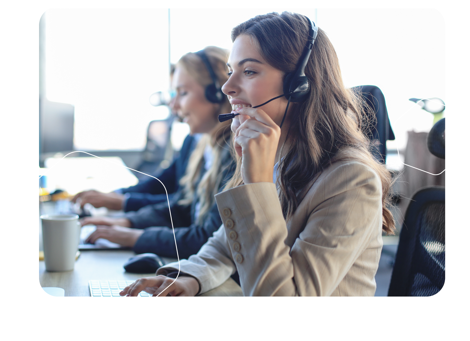 Three people wearing headsets working at computers in an office setting.