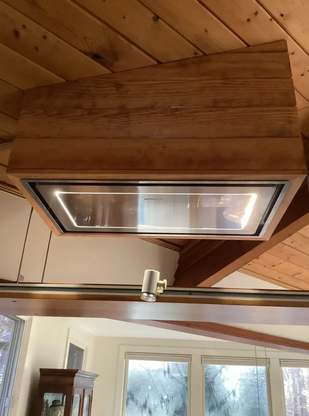 Wood-paneled ceiling with a rectangular fluorescent light fixture above a doorway.