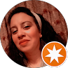 Portrait of a smiling woman in a circular profile photo with an orange star badge overlay