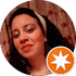Portrait of a smiling woman in a circular profile photo with an orange star badge overlay