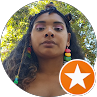 Portrait of a woman outdoors, wearing colorful earrings, with an orange star badge in the corner