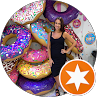 Woman posing by colorful painted stone steps with circular art and orange star logo