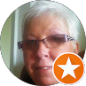 Close-up portrait of a person with short gray hair and glasses, with an orange star badge overlay