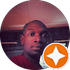 Portrait of a person indoors, with a white star badge overlay in the lower right.