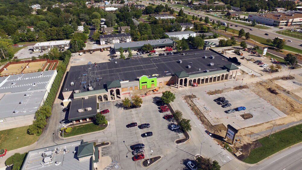 Aerial view of a strip mall with parking lot, cars, and a road nearby | Lindner Properties Nifong