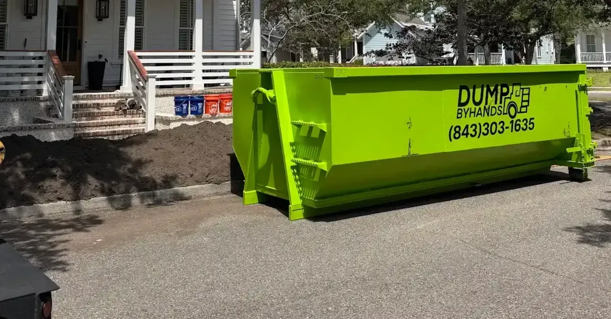 Green roll-off dumpster parked on Charleston street