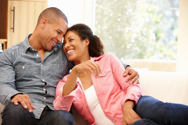 Smiling couple standing in their newly painted living room