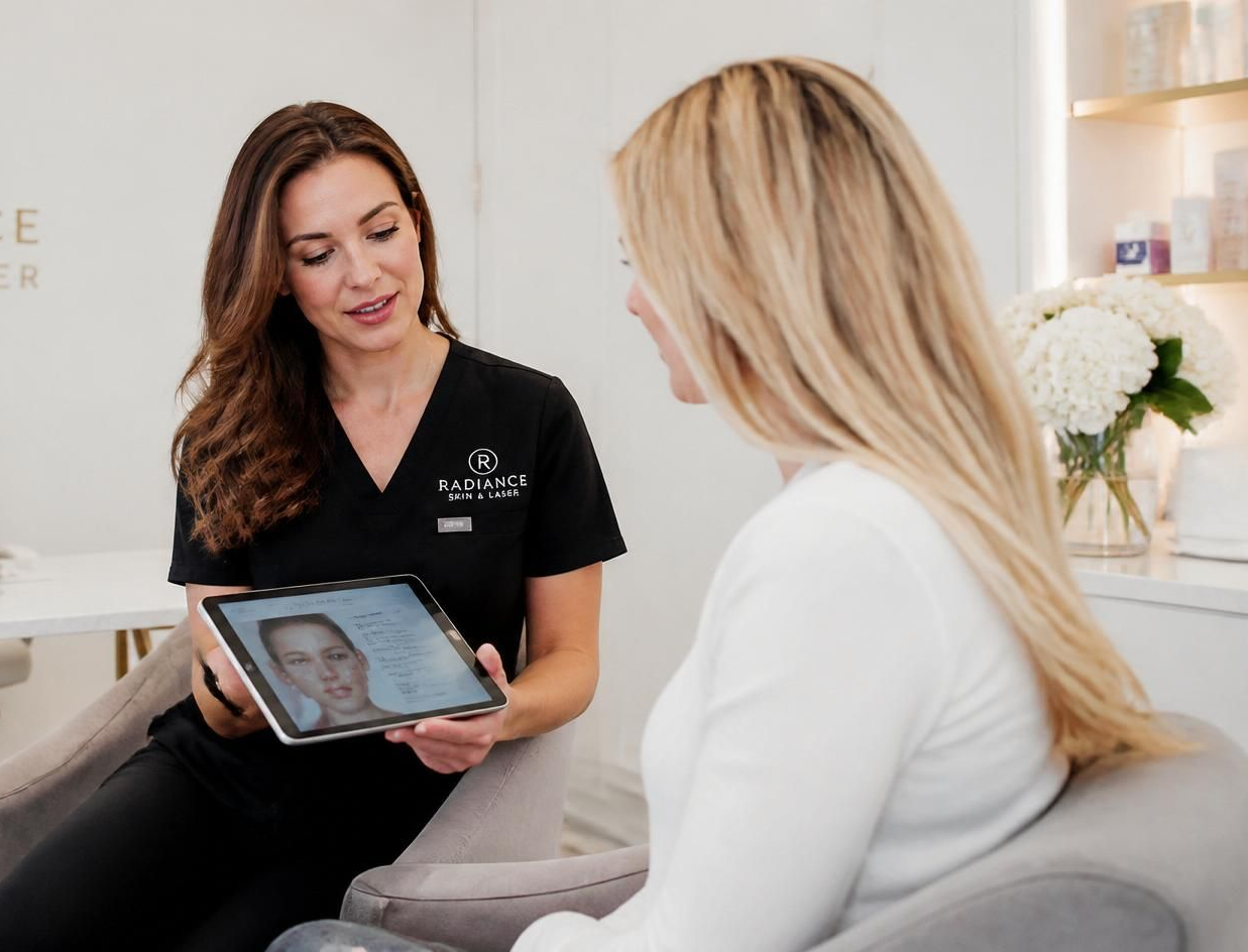 Clinician showing a tablet to a seated client in a bright medical office