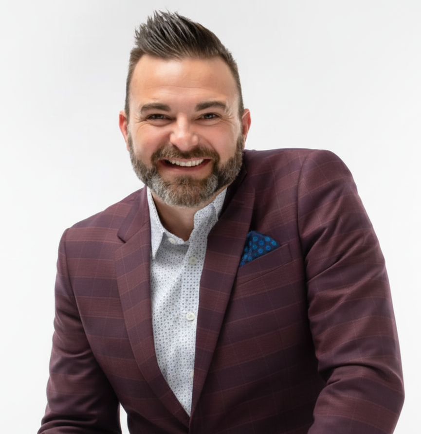 Smiling man in a maroon blazer and blue pocket square against a white background