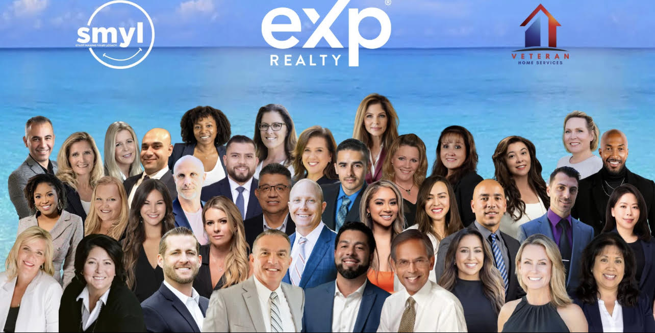 Group of real estate agents posing in front of a blue sky with smyl and eXp Realty logos.