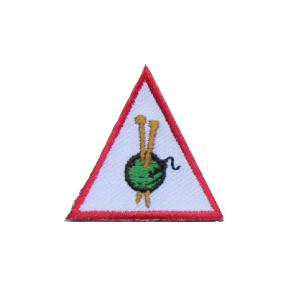 A triangle with a green ball of yarn and knitting needles on it badge.