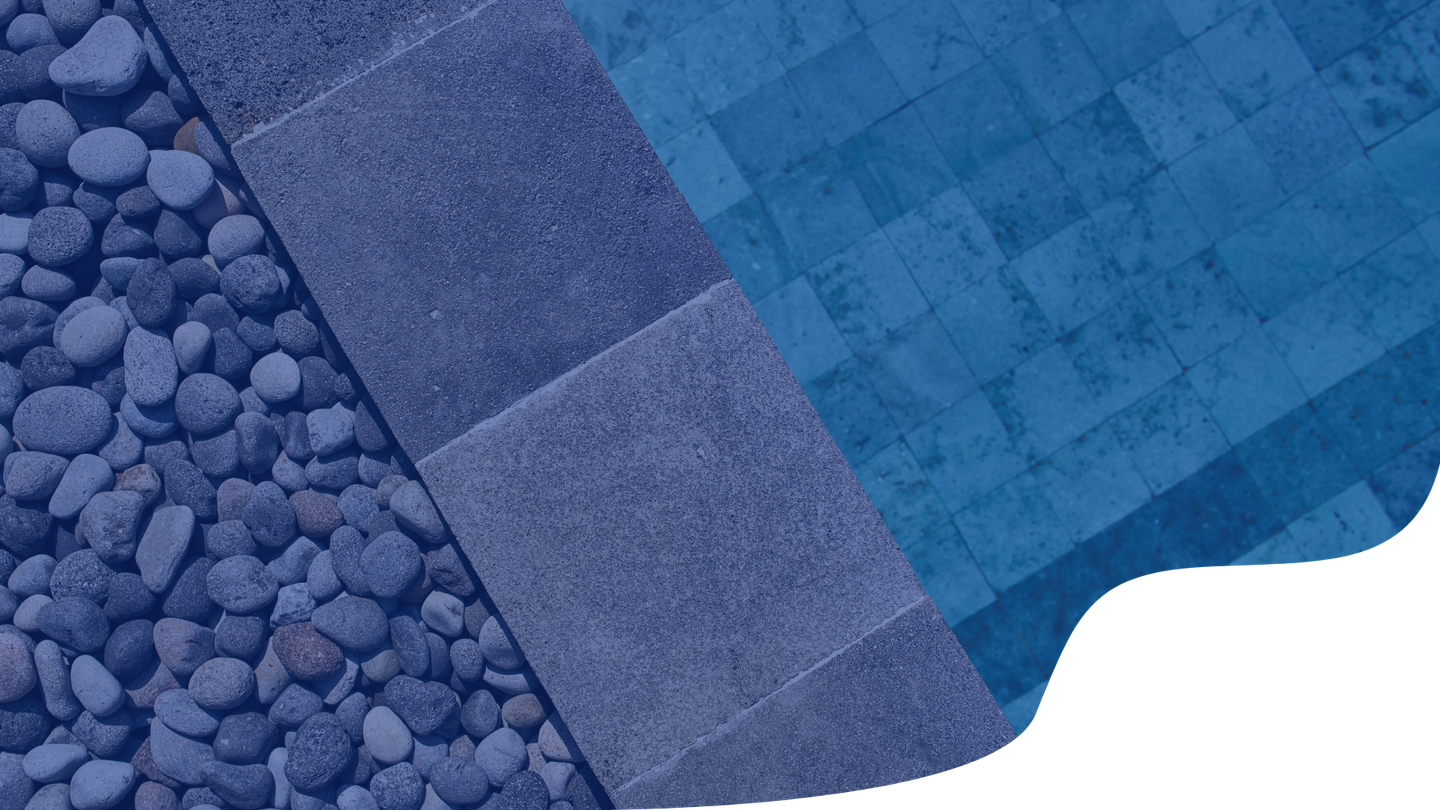 A swimming pool with blue tiles and rocks surrounding it.