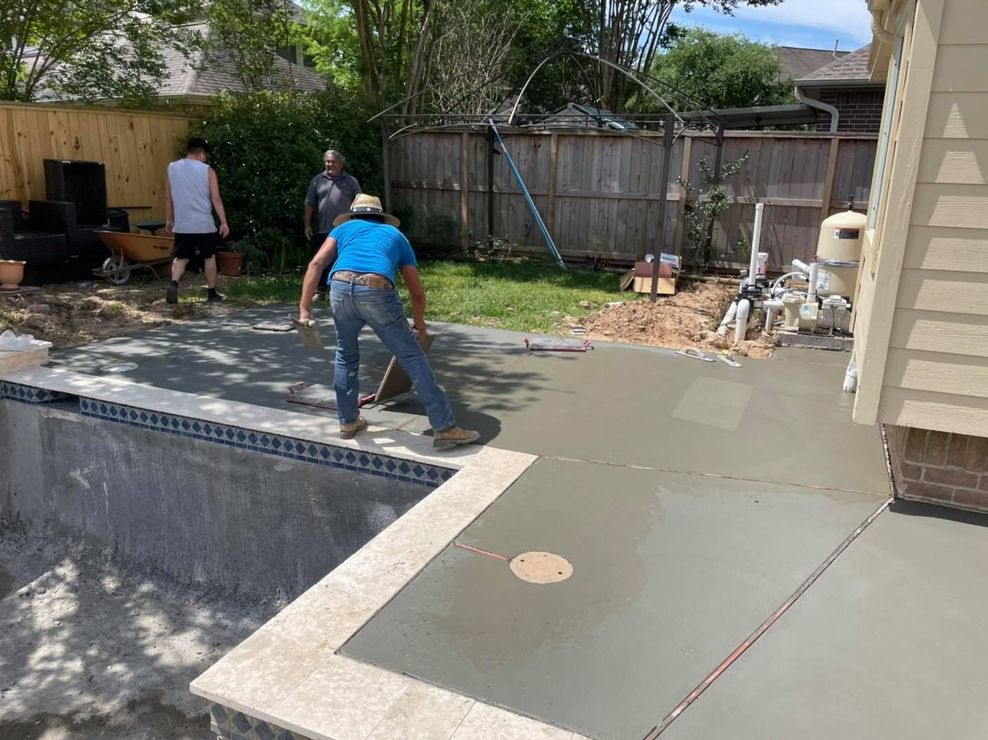 A man is standing next to a swimming pool in a backyard.