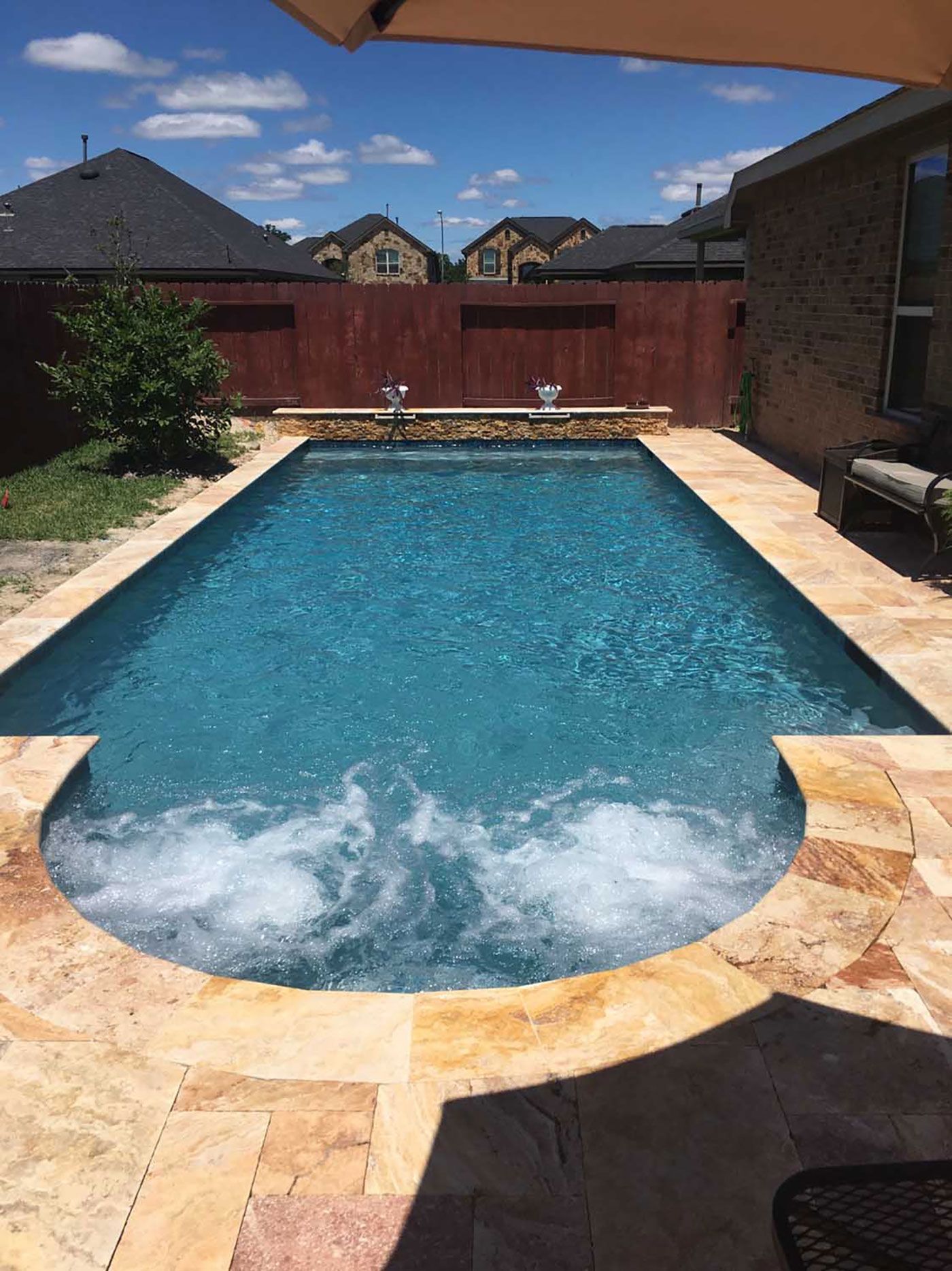 A large swimming pool with a jacuzzi in the middle of it