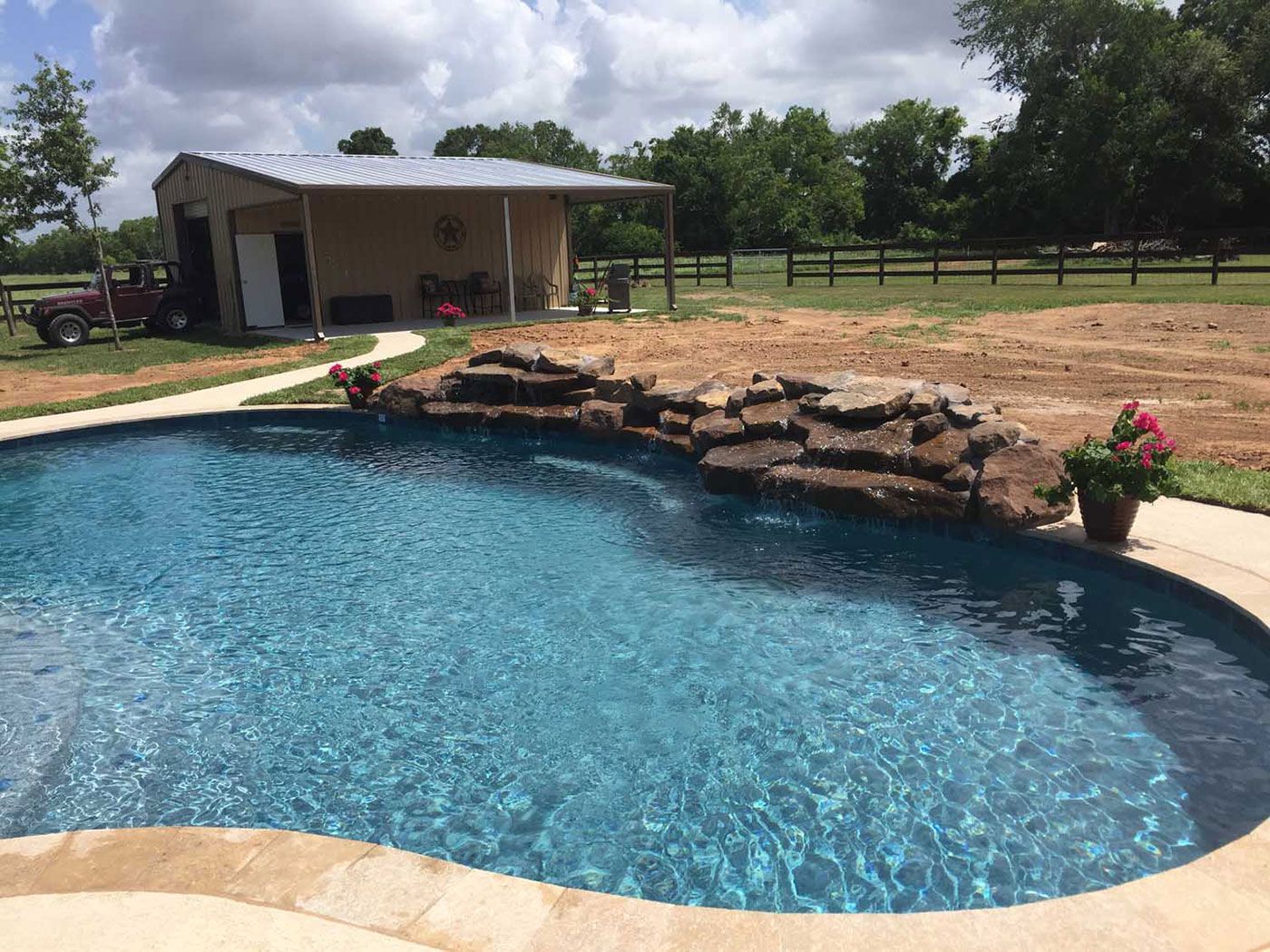 A large swimming pool with a waterfall in the middle of it.