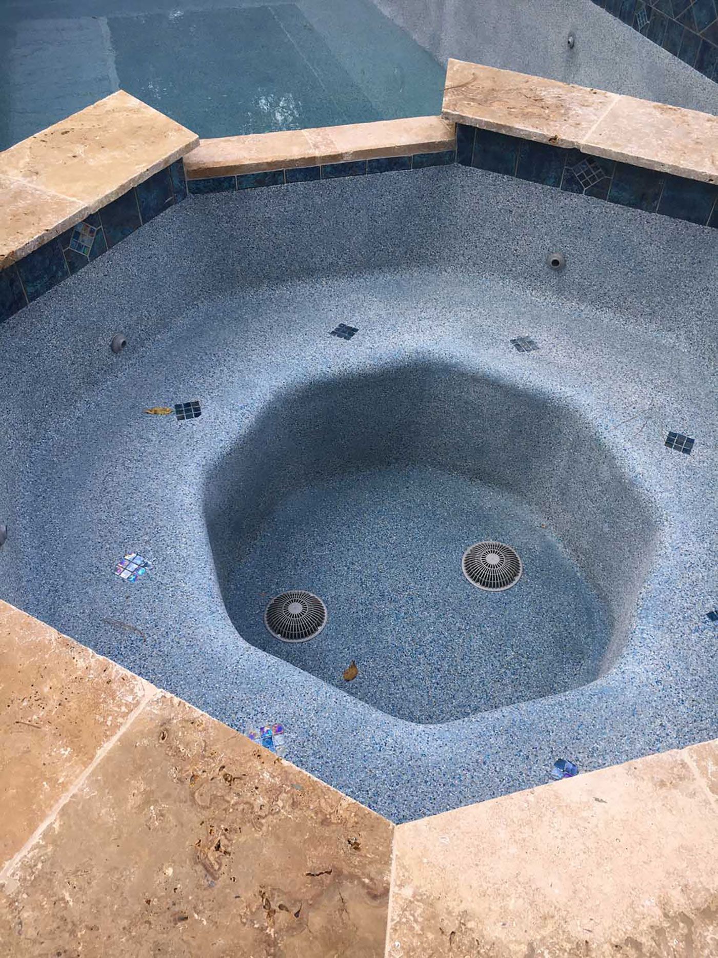 A hot tub in the middle of a swimming pool.