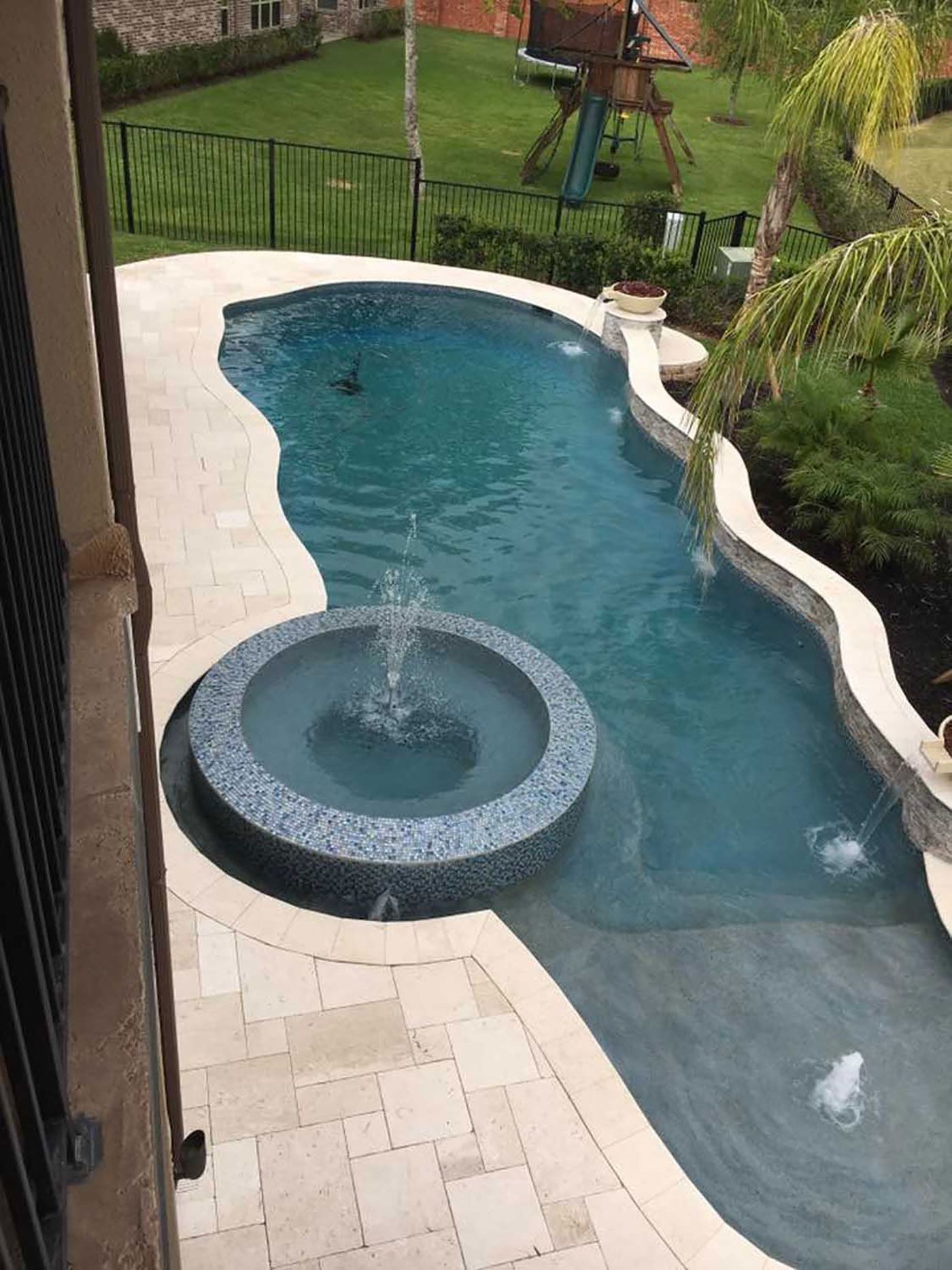 A large swimming pool with a fountain in the middle of it.