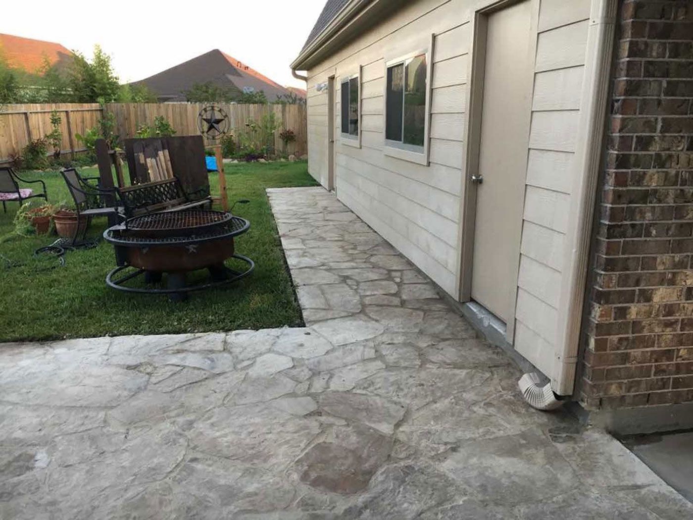 There is a fire pit in the backyard of a house.