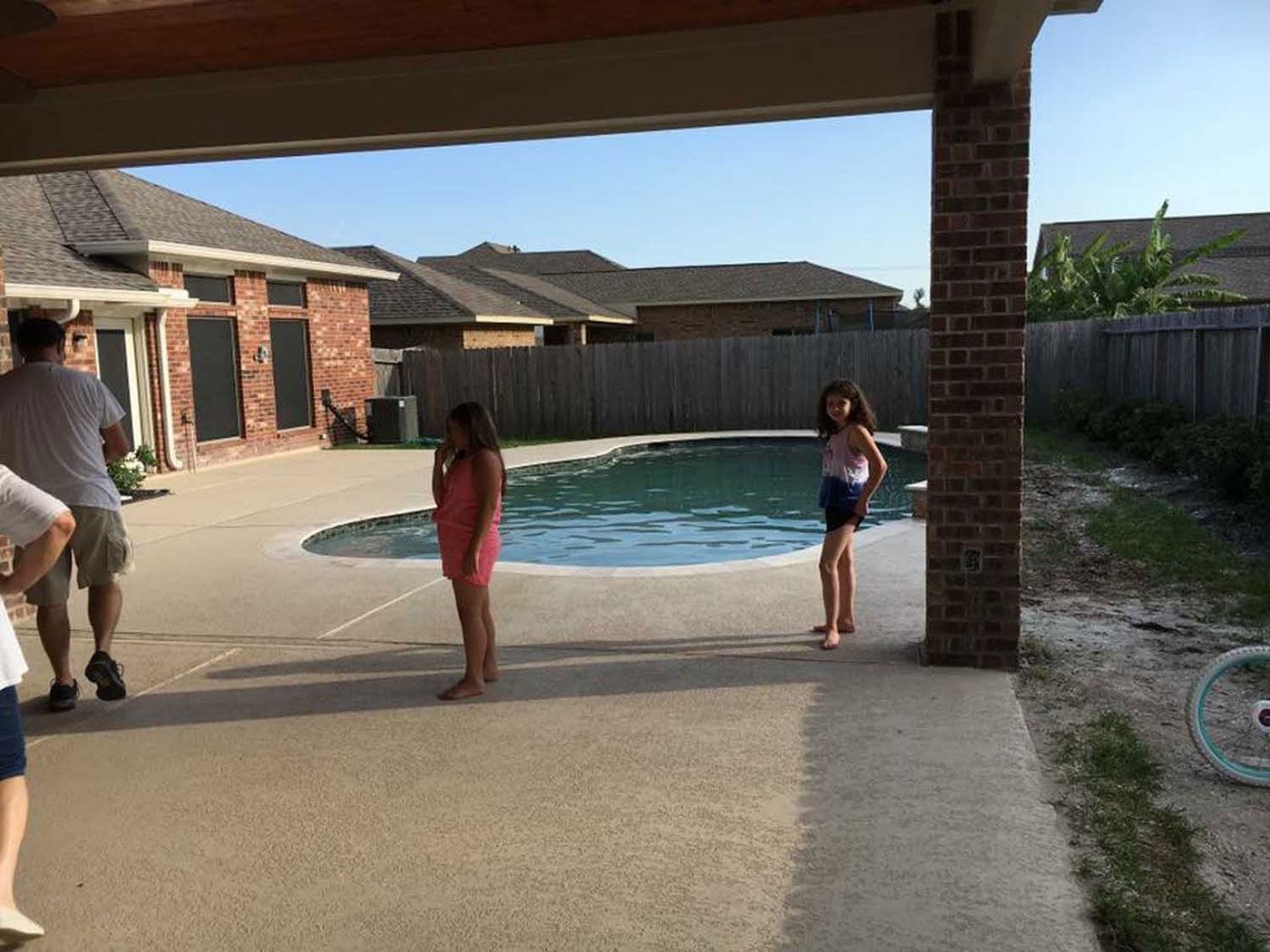 A group of people are standing in front of a swimming pool.