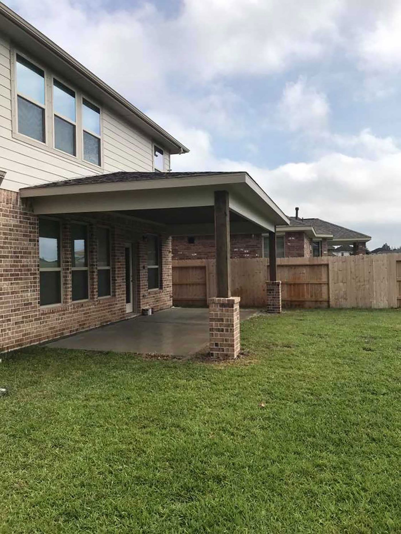 A large house with a covered patio in the backyard.