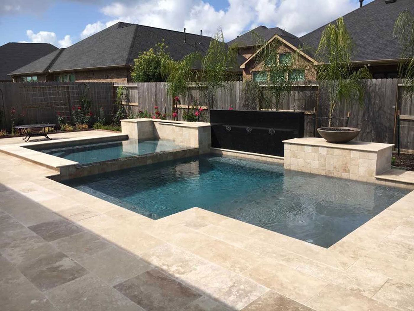 A large swimming pool is in the backyard of a house.