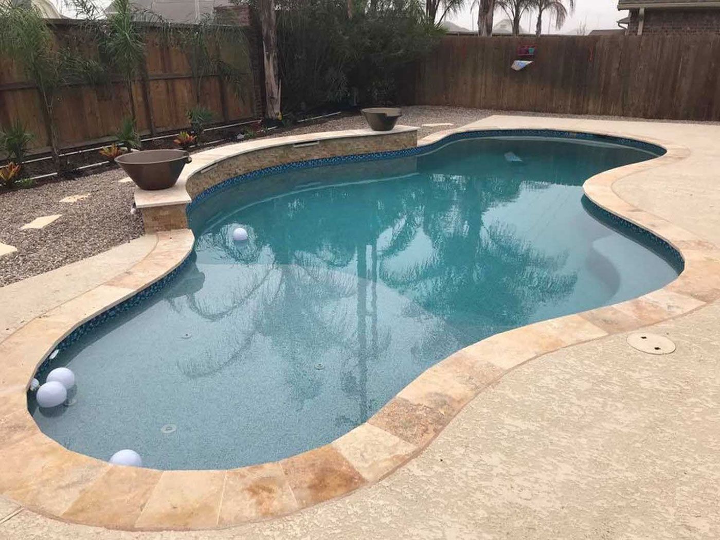 A large swimming pool is sitting on top of a concrete patio.