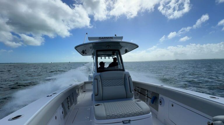 Boat speeding across ocean under a partly cloudy sky.