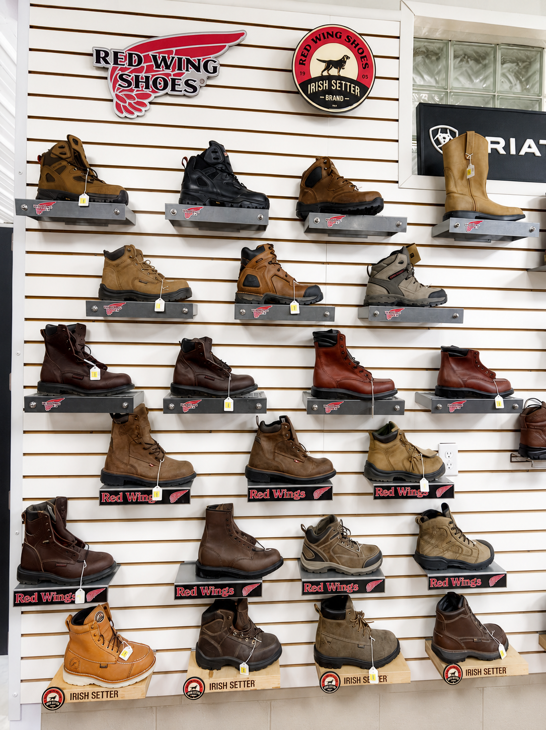 Shoes hanging and piled in a crowded market stall, showcasing a variety of colors and styles.
