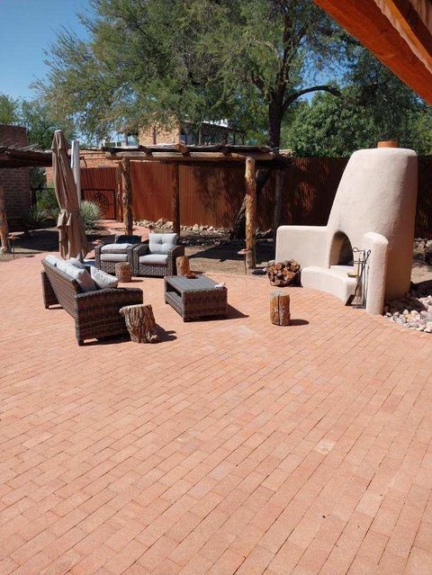Brick patio with outdoor seating and a stucco fireplace.