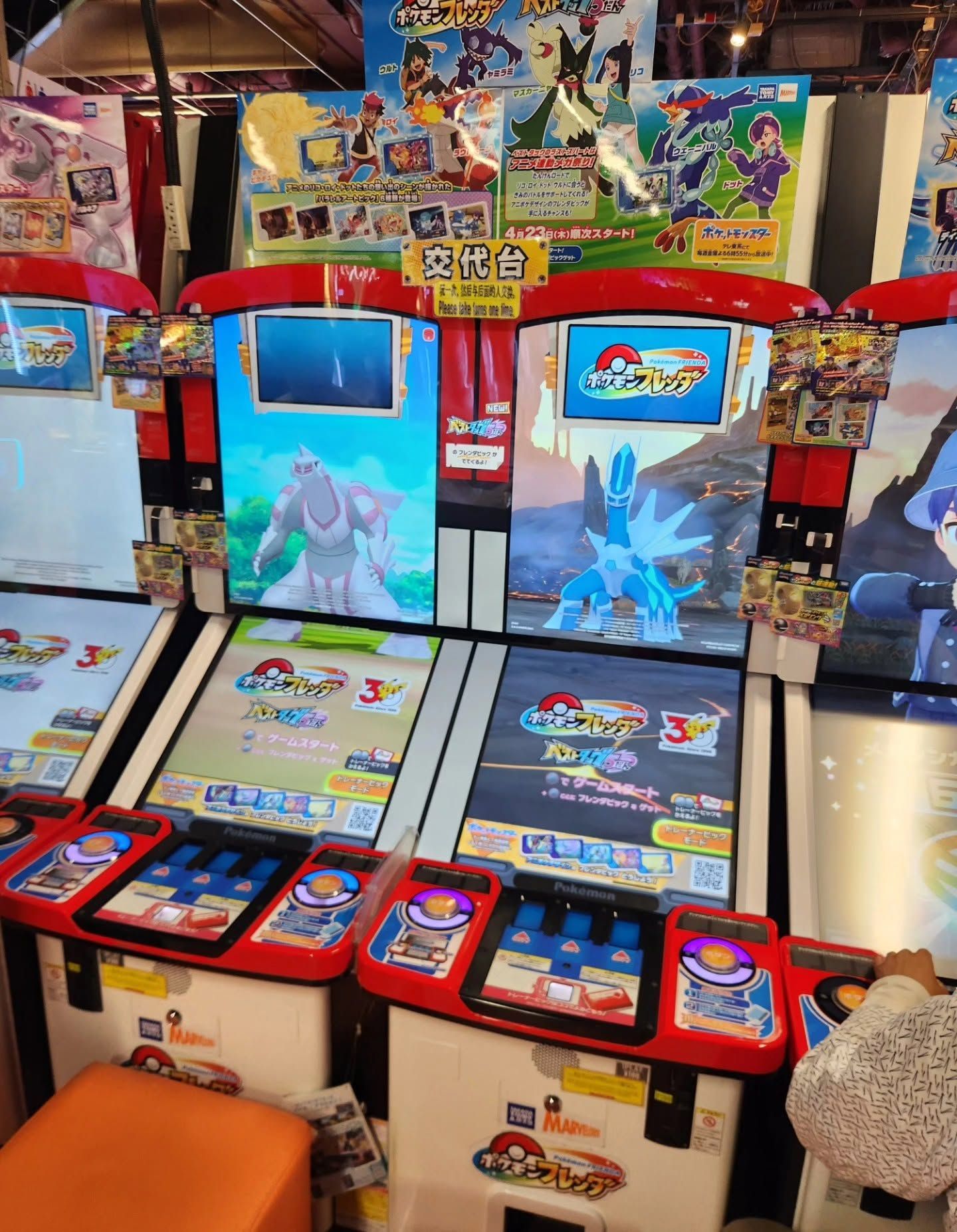 Row of colorful arcade game cabinets with bright cartoon screens in an indoor amusement center