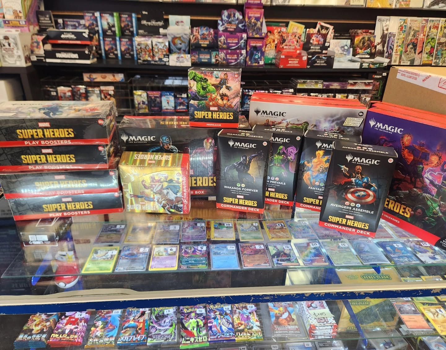 Assorted trading card game boxes and packs displayed on store shelves in a colorful game shop.