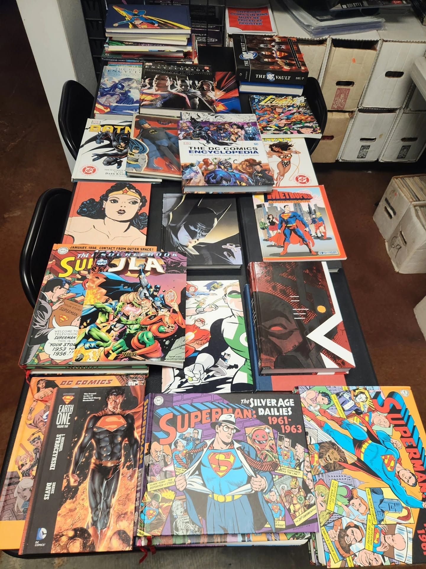 Assorted comic books and manga arranged in stacks on a table in a room