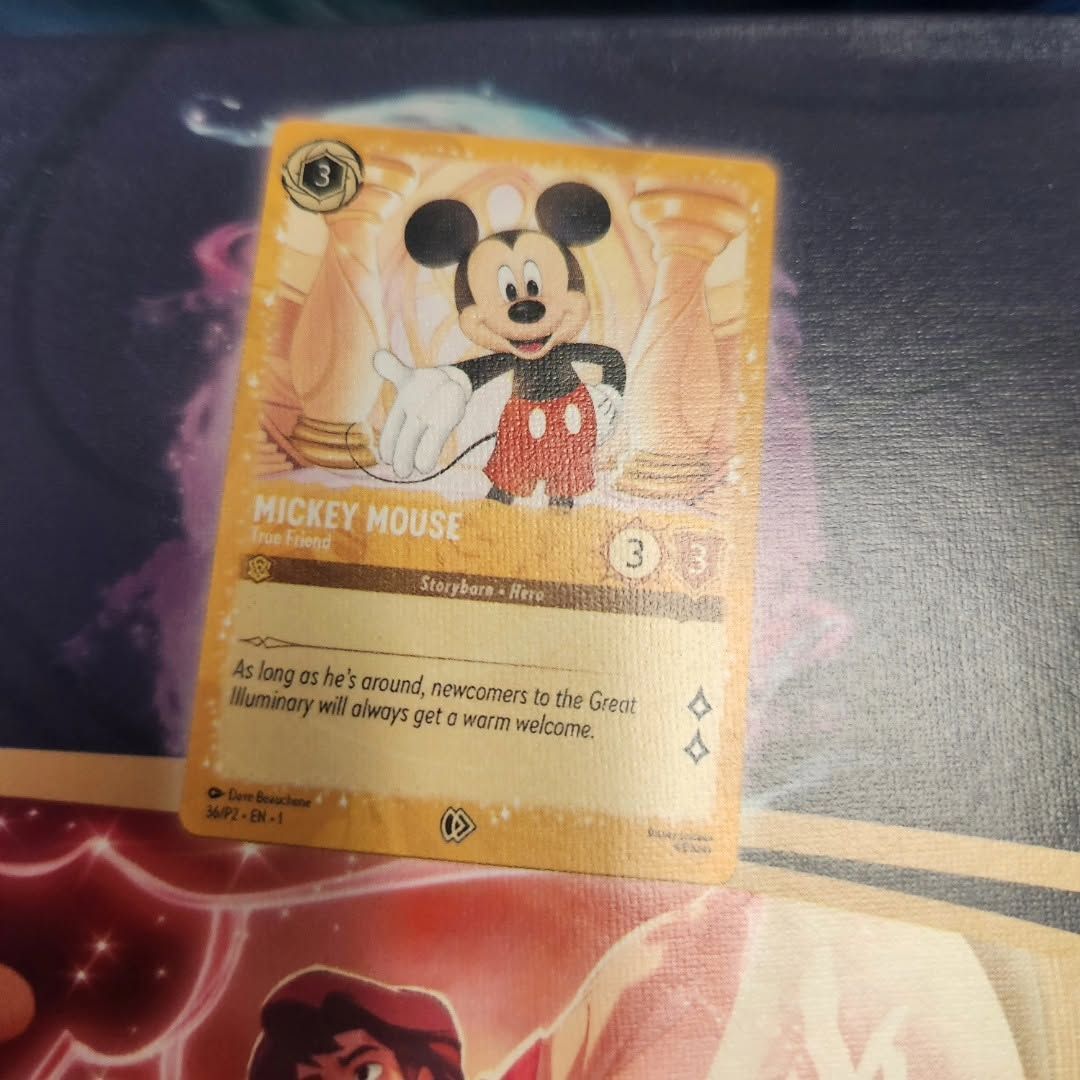 Mickey Mouse trading card on a surface, with orange background and game stats visible