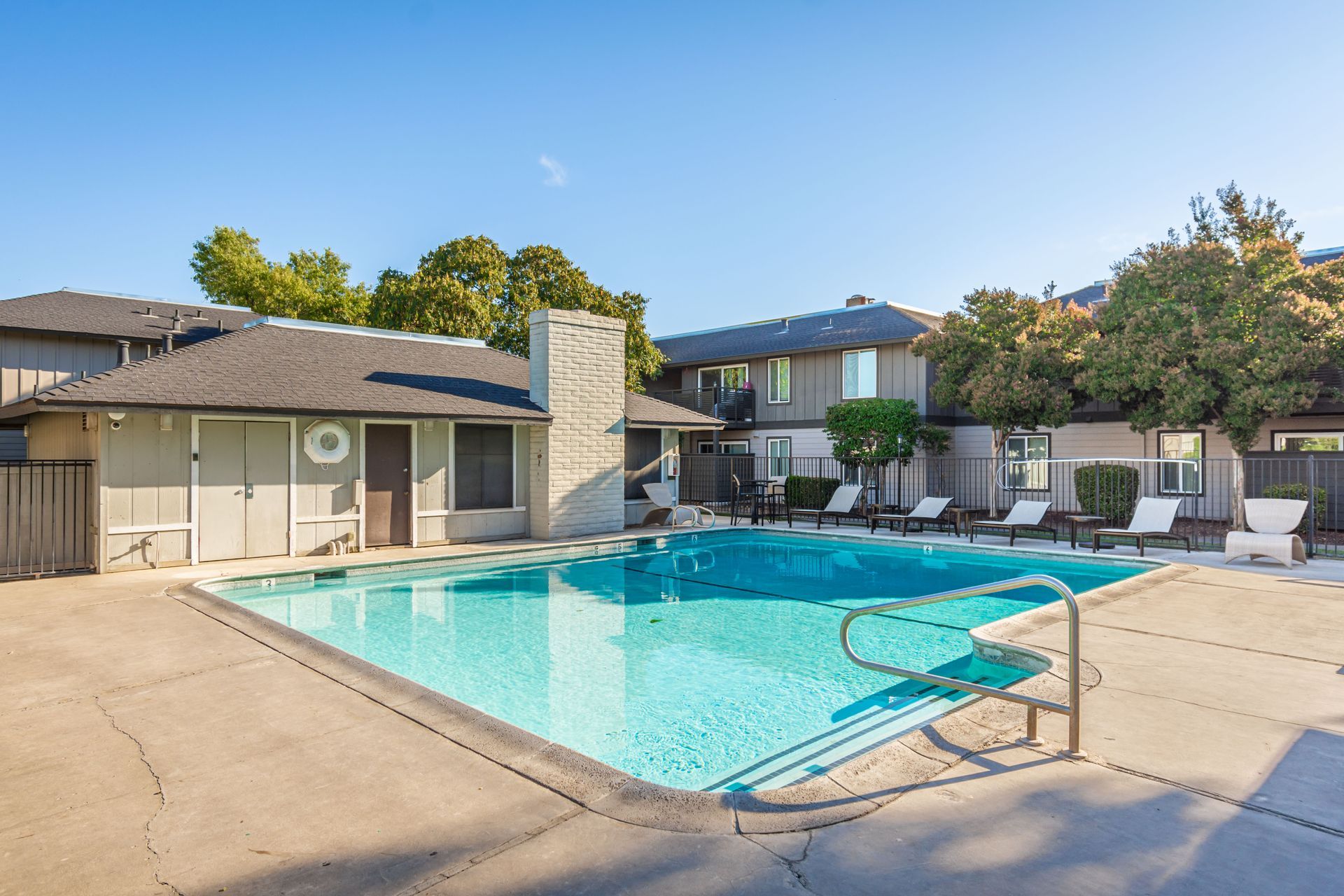 There is a large swimming pool in front of a building.