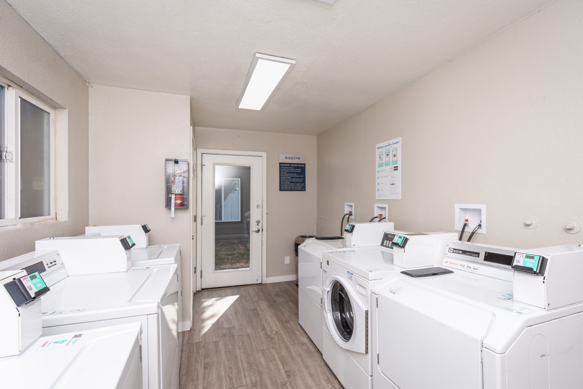 A laundry room with a lot of washers and dryers.