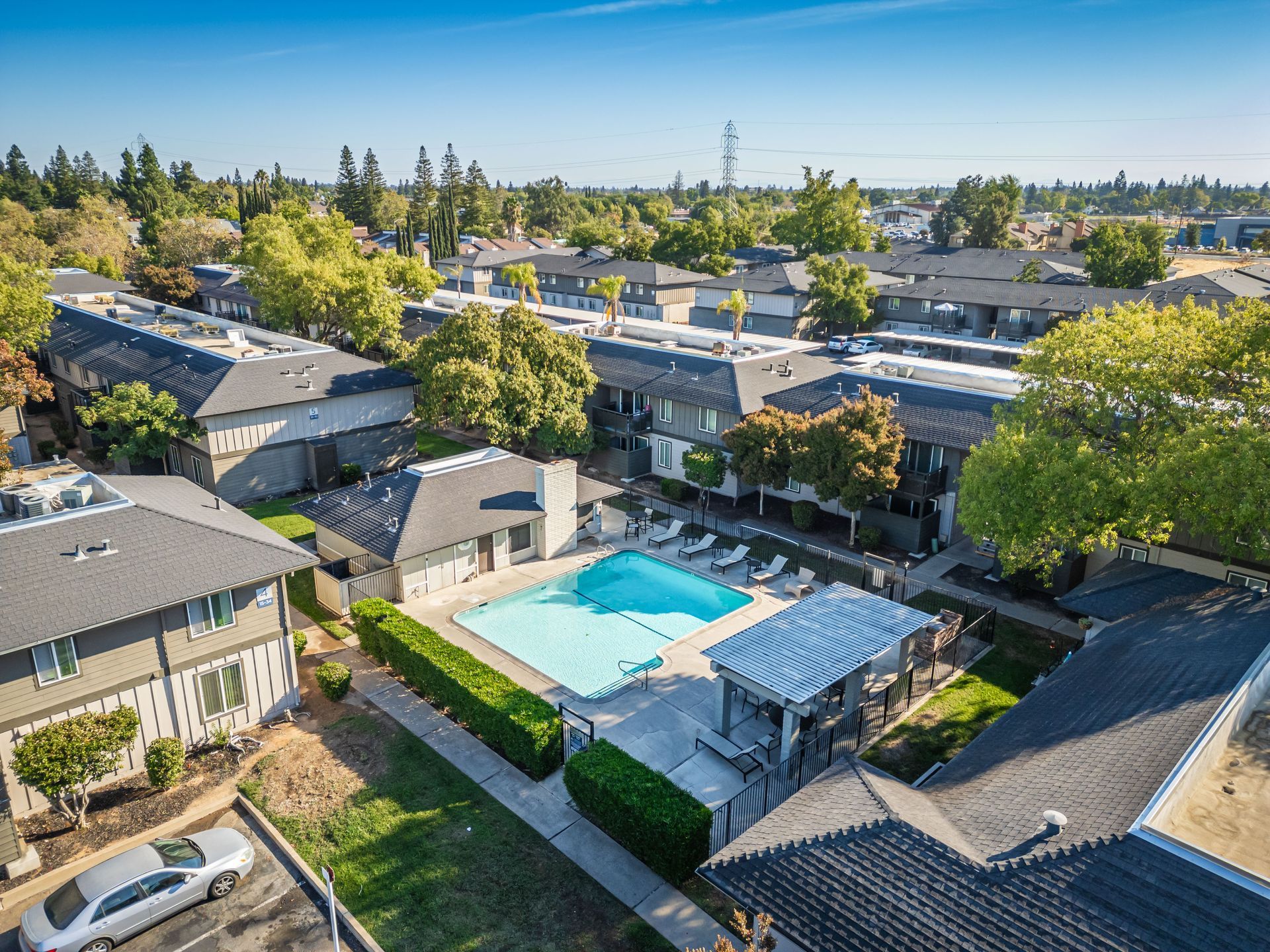 An aerial view of a residential area with a large swimming pool surrounded by buildings.
