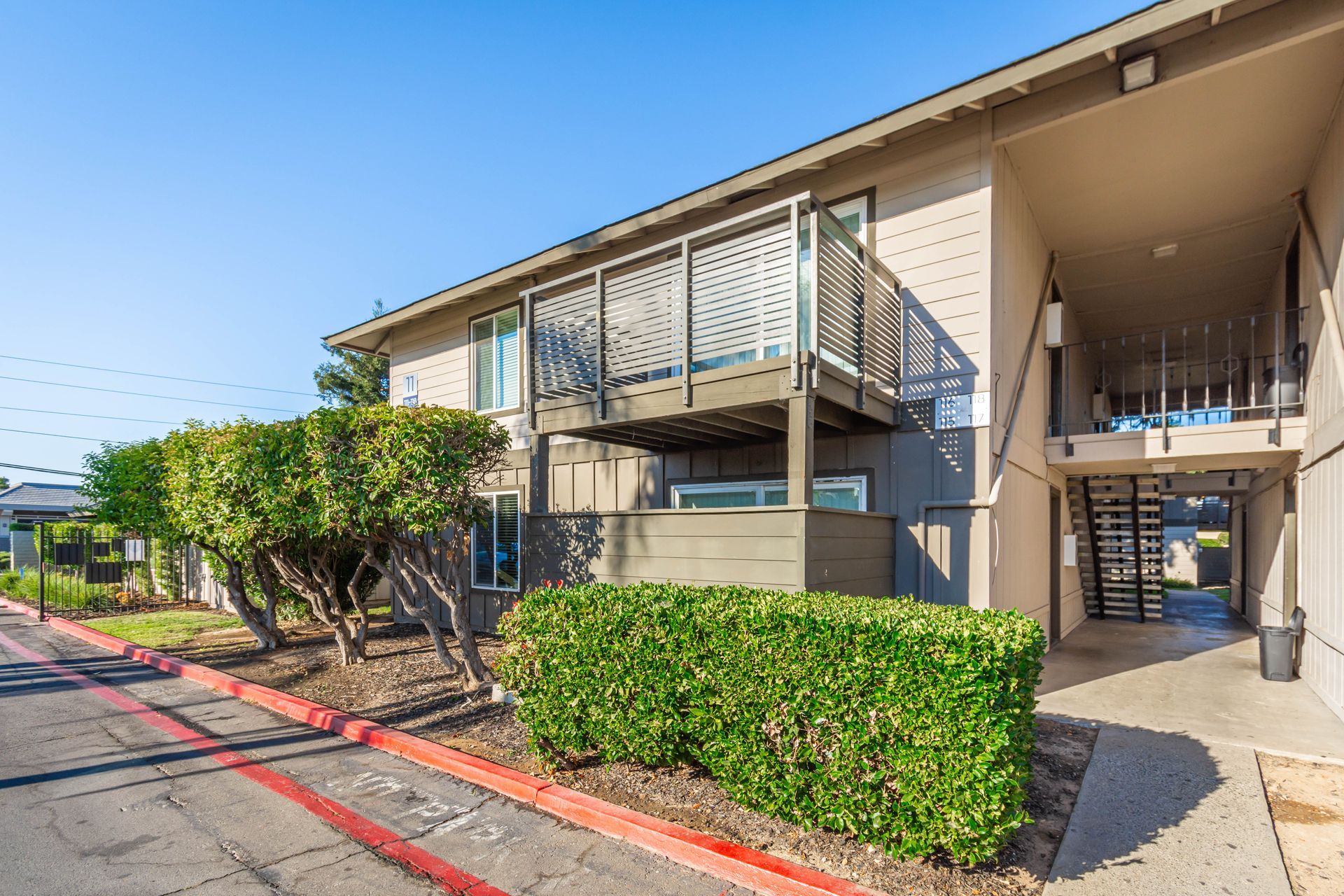A large apartment building with a balcony and a walkway leading to it.