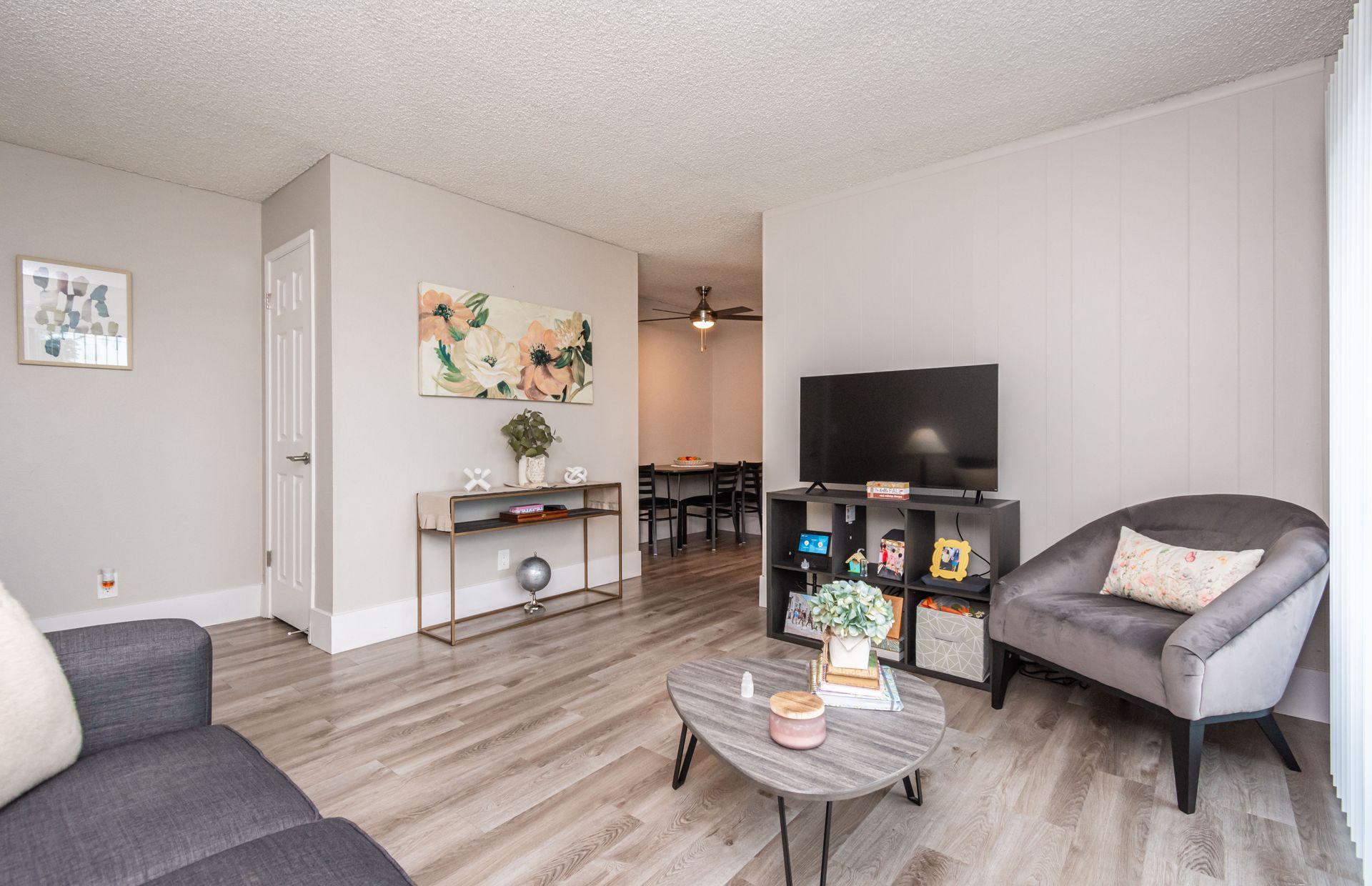 A living room with a couch , chair , coffee table and television.