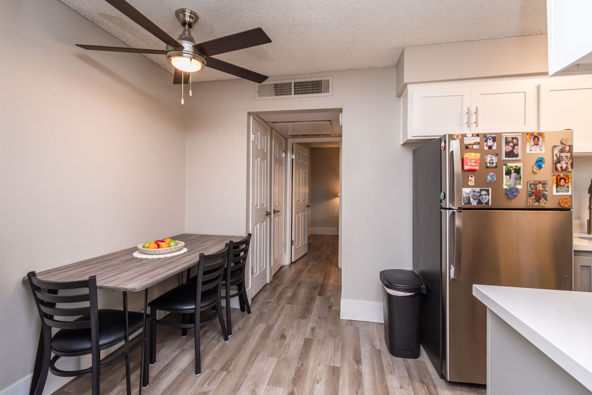 A kitchen with a table and chairs and a refrigerator